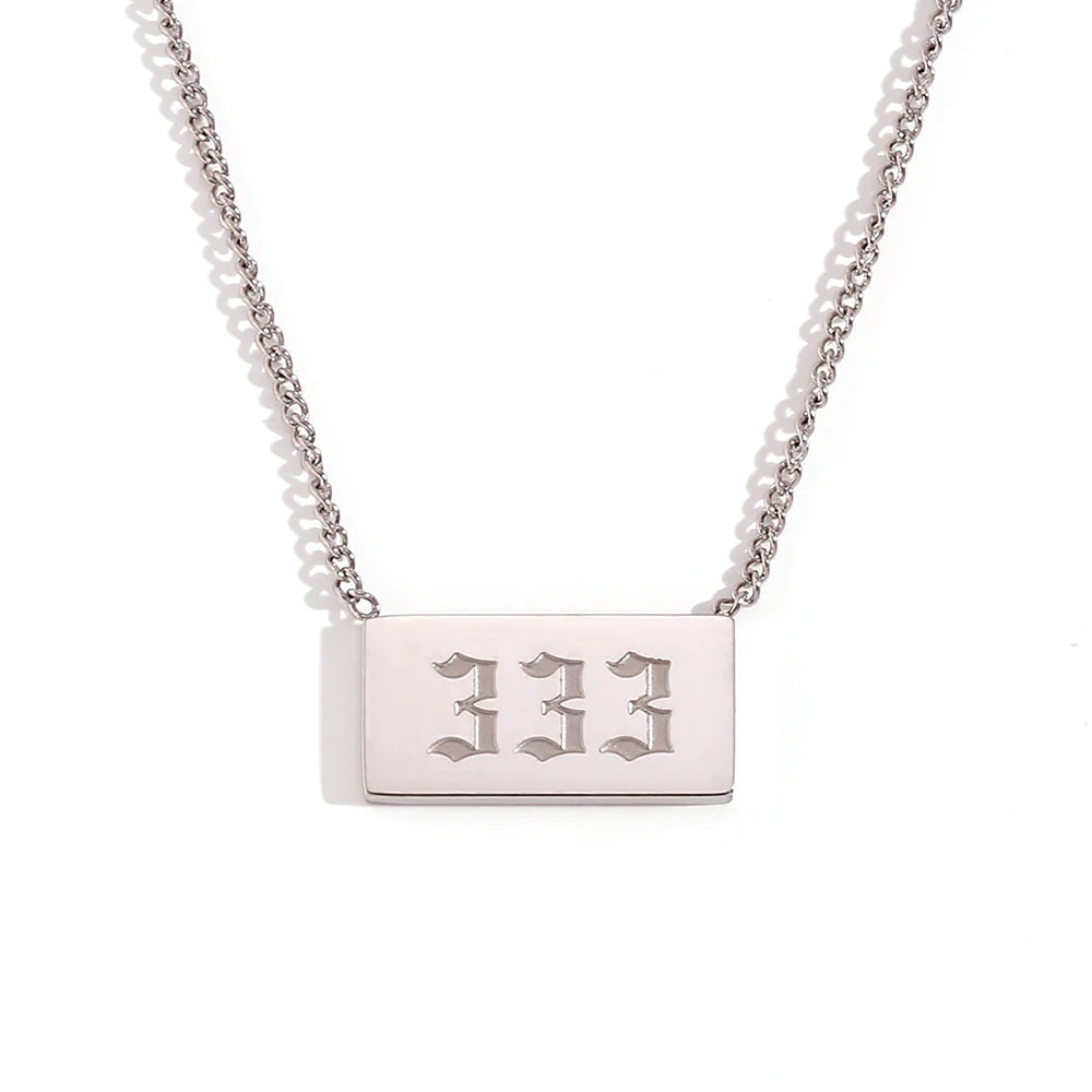 Silver necklace with a rectangular tag engraved with '333' on a white background